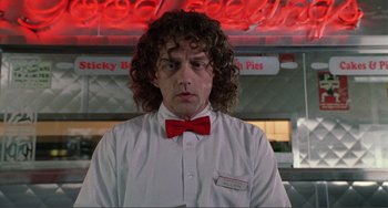 Movie still from “Ghost World” (2001), directed by Terry Zwigoff – A man with curly hair wearing a red bow tie; Close Up shot, Low angle
