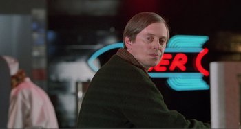 Movie still from “Ghost World” (2001), directed by Terry Zwigoff – A man standing in front of a neon sign; Close Up shot, Over the shoulder angle