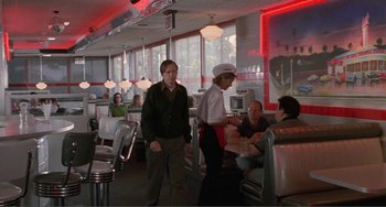 Movie still from “Ghost World” (2001), directed by Terry Zwigoff – A man and a woman are standing in a diner; Wide shot, Over the shoulder angle