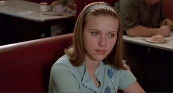 Movie still from “Ghost World” (2001), directed by Terry Zwigoff – A woman sitting at a table in front of a table; Close Up shot, Over the shoulder angle