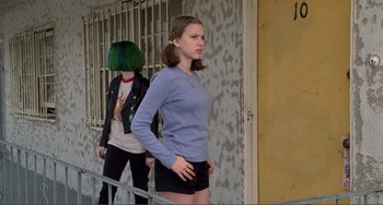 Movie still from “Ghost World” (2001), directed by Terry Zwigoff – A woman standing next to another woman in a blue shirt; Medium shot, Low angle