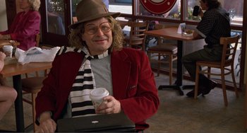 Movie still from “Ghost World” (2001), directed by Terry Zwigoff – An older woman wearing a hat and holding a cup of coffee; Medium shot, Over the shoulder angle