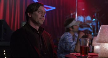 Movie still from “Ghost World” (2001), directed by Terry Zwigoff – A man sitting in front of another man at a bar; Medium shot, Over the shoulder angle