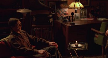 Movie still from “Ghost World” (2001), directed by Terry Zwigoff – An older man sitting in a chair in a living room; Wide shot, High angle