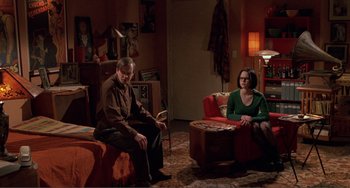 Movie still from “Ghost World” (2001), directed by Terry Zwigoff – A man and a woman sitting on a couch in a living room; Wide shot, High angle