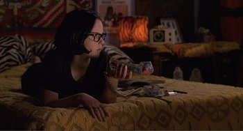 Movie still from “Ghost World” (2001), directed by Terry Zwigoff – A woman sitting on a bed playing a video game; Medium shot, High angle