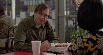 Movie still from “Ghost World” (2001), directed by Terry Zwigoff – A man sitting at a table with a bowl of food in front of him; Medium shot, Over the shoulder angle