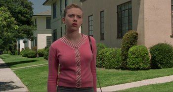 Movie still from “Ghost World” (2001), directed by Terry Zwigoff – A woman in a pink sweater standing in front of a building; Medium shot, Low angle