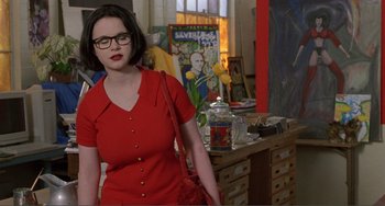 Movie still from “Ghost World” (2001), directed by Terry Zwigoff – A woman in a red dress standing in a room; Medium shot, Over the shoulder angle