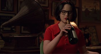 Movie still from “Ghost World” (2001), directed by Terry Zwigoff – A woman in a red shirt is holding a bottle of champagne; Medium shot, High angle