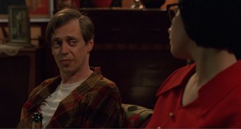 Movie still from “Ghost World” (2001), directed by Terry Zwigoff – A man and a woman sitting on a couch in a room; Close Up shot, Over the shoulder angle