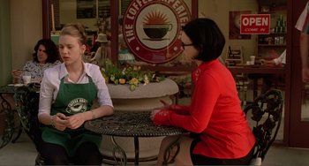 Movie still from “Ghost World” (2001), directed by Terry Zwigoff – Two women sitting at a table in front of a coffee shop sign; Medium shot, Over the shoulder angle