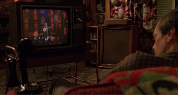 Movie still from “Ghost World” (2001), directed by Terry Zwigoff – A television set in a living room next to a couch; Wide shot, High angle