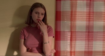 Movie still from “Ghost World” (2001), directed by Terry Zwigoff – A woman in a pink shirt is leaning against a wall; Medium shot, Low angle
