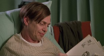 Movie still from “Ghost World” (2001), directed by Terry Zwigoff – A man sitting on a couch looking at a piece of paper; Close Up shot, Low angle