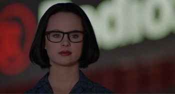 Movie still from “Ghost World” (2001), directed by Terry Zwigoff – A woman with short black hair wearing glasses and a plaid shirt; Close Up shot, Low angle