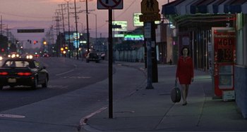 Movie still from “Ghost World” (2001), directed by Terry Zwigoff – A woman in a red dress walking down a street; Extreme Wide shot, High angle