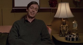 Movie still from “Ghost World” (2001), directed by Terry Zwigoff – A man sitting in front of a lamp in a room; Medium shot, High angle