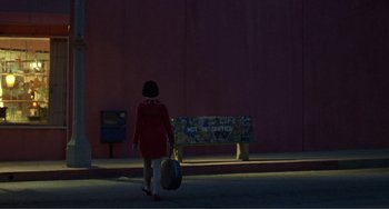 Movie still from “Ghost World” (2001), directed by Terry Zwigoff – A woman in a red dress walking down a street; Extreme Wide shot, Over the shoulder angle