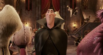 Movie still from “Hotel Transylvania” (2012), directed by Genndy Tartakovsky – A man dressed as dracula in a room with red drapes; Medium shot, Over the shoulder angle