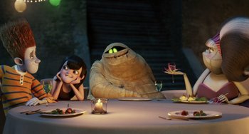 Movie still from “Hotel Transylvania” (2012), directed by Genndy Tartakovsky – A group of people sitting at a table with food; Wide shot, Over the shoulder angle