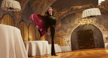 A man dressed as dracula is standing in front of a table