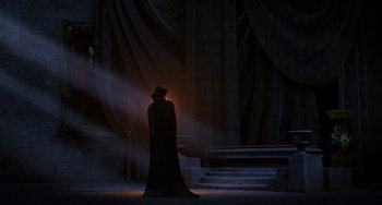 Movie still from “Hotel Transylvania” (2012), directed by Genndy Tartakovsky – A man in a long black coat and a black hat; Wide shot, Over the shoulder angle