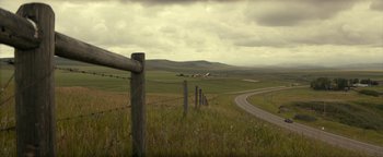 Movie still from “Ghostbusters: Afterlife” (2021), directed by Jason Reitman – A road going through the middle of a grassy field; Extreme Wide shot, High angle