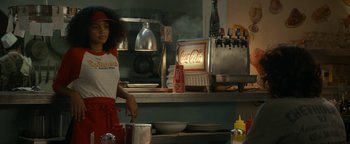 Movie still from “Ghostbusters: Afterlife” (2021), directed by Jason Reitman – A woman standing in front of a stove in a kitchen; Medium shot, Over the shoulder angle