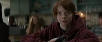 Movie still from “Ghostbusters: Afterlife” (2021), directed by Jason Reitman – A young boy sitting at a table holding a bowl; Close Up shot, Over the shoulder angle