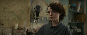 Movie still from “Ghostbusters: Afterlife” (2021), directed by Jason Reitman – A person wearing glasses in a room; Close Up shot, Over the shoulder angle