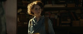 Movie still from “Ghostbusters: Afterlife” (2021), directed by Jason Reitman – A woman with glasses is standing in a room; Close Up shot, Low angle