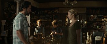 Movie still from “Ghostbusters: Afterlife” (2021), directed by Jason Reitman – Three people in a room with books on the wall; Medium shot, Low angle