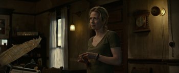 Movie still from “Ghostbusters: Afterlife” (2021), directed by Jason Reitman – A woman standing in front of a window holding a cell phone; Medium shot, Over the shoulder angle