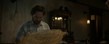 Movie still from “Ghostbusters: Afterlife” (2021), directed by Jason Reitman – A man is looking at an old paper umbrella; Medium shot, High angle