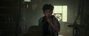 Movie still from “Ghostbusters: Afterlife” (2021), directed by Jason Reitman – A young boy is eating something while sitting in a chair; Close Up shot, Low angle