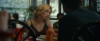 Movie still from “Ghostbusters: Afterlife” (2021), directed by Jason Reitman – A woman sitting at a table in front of a man; Medium shot, Over the shoulder angle