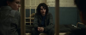 Movie still from “Ghostbusters: Afterlife” (2021), directed by Jason Reitman – A person sitting on a bench in a room; Medium shot, Over the shoulder angle