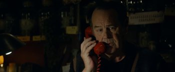 Movie still from “Ghostbusters: Afterlife” (2021), directed by Jason Reitman – A man holding a red phone up to his ear; Close Up shot, Low angle