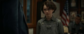 Movie still from “Ghostbusters: Afterlife” (2021), directed by Jason Reitman – A young person wearing glasses and a gray shirt; Medium shot, Over the shoulder angle