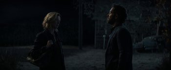 Movie still from “Ghostbusters: Afterlife” (2021), directed by Jason Reitman – A man and a woman standing next to each other in the dark; Medium shot, Over the shoulder angle