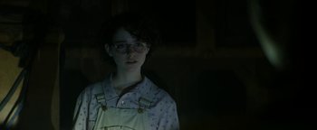 Movie still from “Ghostbusters: Afterlife” (2021), directed by Jason Reitman – A person with glasses is standing in the dark; Close Up shot, Low angle