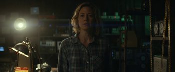 Movie still from “Ghostbusters: Afterlife” (2021), directed by Jason Reitman – A woman standing in a room with lights in the background; Medium shot, Over the shoulder angle