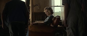 Movie still from “Ghostbusters: Afterlife” (2021), directed by Jason Reitman – A woman sitting in a chair in a living room; Medium shot, Low angle