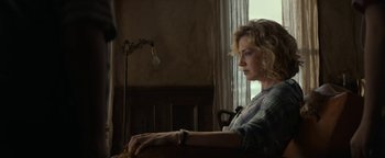 Movie still from “Ghostbusters: Afterlife” (2021), directed by Jason Reitman – A woman sitting in a chair in front of a window; Medium shot, Low angle