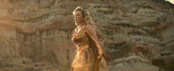 Movie still from “Ghostbusters: Afterlife” (2021), directed by Jason Reitman – A woman in a gold dress standing in front of a cliff; Medium shot, Low angle