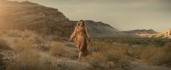 Movie still from “Ghostbusters: Afterlife” (2021), directed by Jason Reitman – A woman in a dress walking on a dirt path; Wide shot, Low angle
