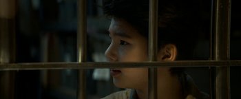 Movie still from “Ghostbusters: Afterlife” (2021), directed by Jason Reitman – A young boy looking out of a jail cell; Close Up shot, High angle