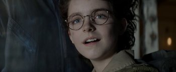 Movie still from “Ghostbusters: Afterlife” (2021), directed by Jason Reitman – A young woman wearing glasses looking up at the sky; Close Up shot, Low angle
