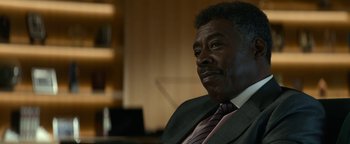 Movie still from “Ghostbusters: Afterlife” (2021), directed by Jason Reitman – An older man in a suit and tie looking at the camera; Close Up shot, Over the shoulder angle